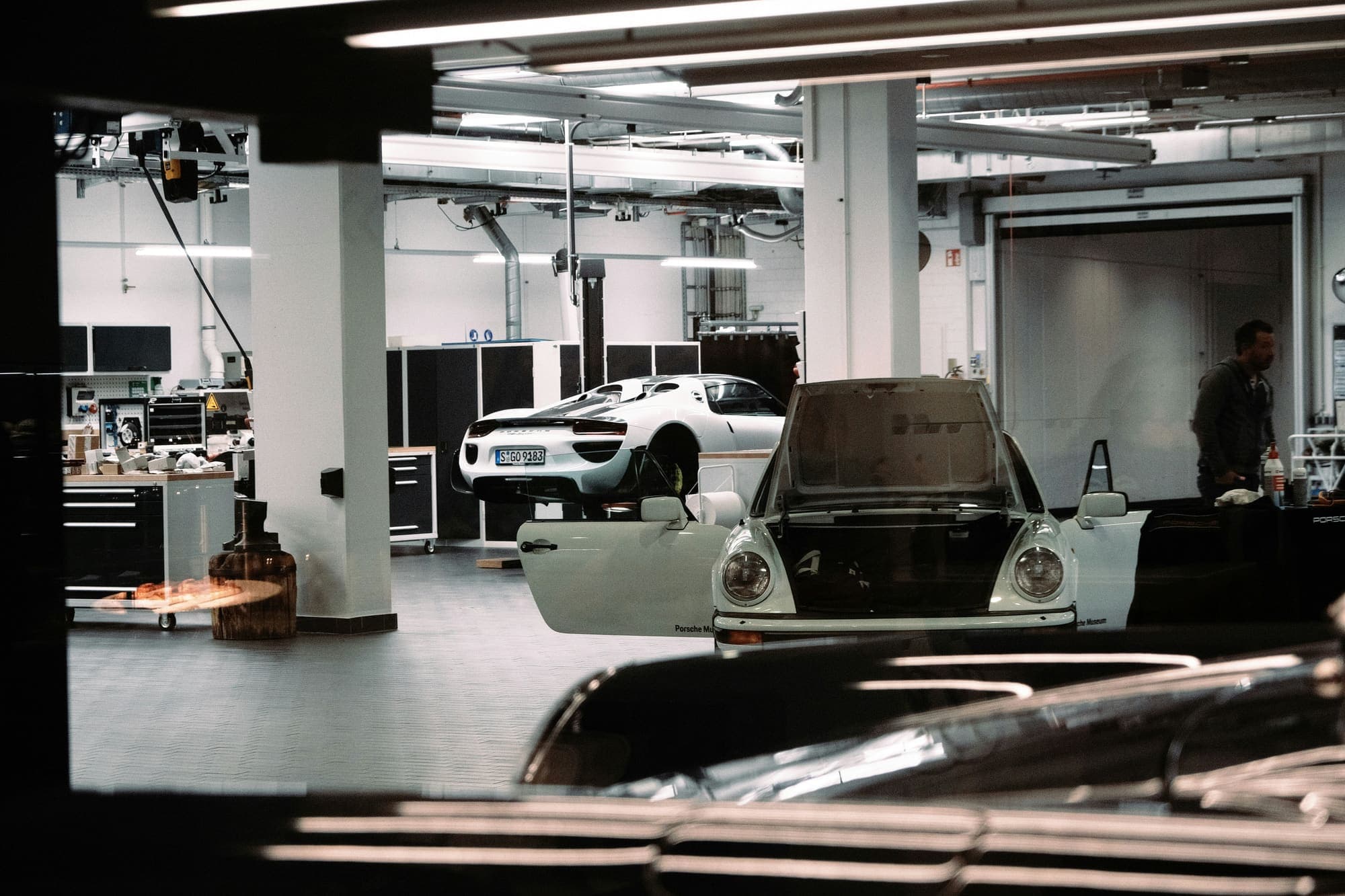 A restoration workshop, a classic car stripped for work under the lights